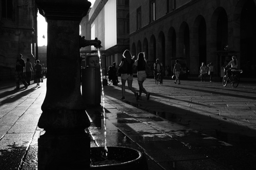 Fontana e persone a passeggio in bianco e nero