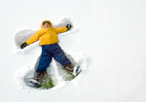 Bambino fa l'angelo della neve