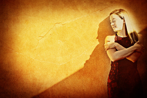 Ragazza appoggiata su una parete al sole